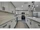 Stylish kitchen featuring white cabinets, stainless steel appliances, and an island with modern countertops at 6306 Aberdeen Ave, New Port Richey, FL 34653