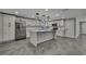 Bright kitchen with stainless steel appliances, an island with pendant lights, and modern white cabinets at 6306 Aberdeen Ave, New Port Richey, FL 34653