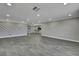 Bright, spacious living room with gray flooring and recessed lighting, open to the kitchen in the background at 6306 Aberdeen Ave, New Port Richey, FL 34653