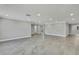 Expansive living area features gray flooring, recessed lights, and a unique wall design with neutral paint color at 6306 Aberdeen Ave, New Port Richey, FL 34653