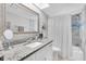 Bright bathroom featuring granite counters, framed mirror, and shower with tub at 755 Green Valley Rd, Palm Harbor, FL 34683