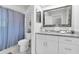Renovated bathroom with granite countertop, white vanity, and shower with blue curtain at 755 Green Valley Rd, Palm Harbor, FL 34683