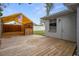Backyard with wooden deck, bar, and adjacent building with siding and a door at 7735 Farmlawn Dr, Port Richey, FL 34668