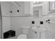 A bathroom featuring tiled walls, a toilet, pedestal sink, shower stall, and mirror at 7735 Farmlawn Dr, Port Richey, FL 34668