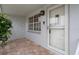 Close-up of the front entry featuring brick flooring and a white storm door at 7735 Farmlawn Dr, Port Richey, FL 34668