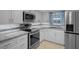 Updated kitchen features stainless steel appliances, granite countertops, and white cabinetry at 7735 Farmlawn Dr, Port Richey, FL 34668