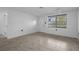 Open living space with a window, tile flooring, and white walls, and a ceiling fan at 7735 Farmlawn Dr, Port Richey, FL 34668