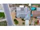 This aerial view showcases the roof, landscaping, proximity to nearby homes, and a glimpse of a community pool at 7736 Gaston Dr, Port Richey, FL 34668