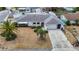 Aerial view of a well-maintained property with landscaping, driveway, and a tidy front yard at 7736 Gaston Dr, Port Richey, FL 34668