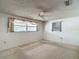 Cozy bedroom with carpet, two windows, and a ceiling fan, offering comfortable living space at 7736 Gaston Dr, Port Richey, FL 34668