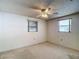 Bedroom featuring carpet, a ceiling fan, and natural light from two windows at 7736 Gaston Dr, Port Richey, FL 34668
