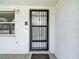Close-up of the home's front door featuring a security gate, textured walls, and a 'welcome' mat at 7736 Gaston Dr, Port Richey, FL 34668