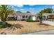 Landscaped front yard with palm trees, shrubbery, and decorative rock at 7736 Gaston Dr, Port Richey, FL 34668