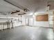 Large garage with work table, overhead racks, white refrigerator, and white door to exterior at 7736 Gaston Dr, Port Richey, FL 34668
