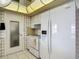 Bright kitchen featuring white appliances, cabinetry, and tile floors at 7736 Gaston Dr, Port Richey, FL 34668