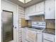 Functional kitchen with white appliances, tile backsplash, and patterned wallpaper accents at 7736 Gaston Dr, Port Richey, FL 34668