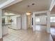 Open-concept kitchen with white appliances and tiled floor leading to a mirrored closet area at 7736 Gaston Dr, Port Richey, FL 34668