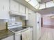 Kitchen featuring modern appliances, including a white refrigerator, stove, and ample cabinet space at 7736 Gaston Dr, Port Richey, FL 34668
