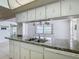Functional kitchen featuring white cabinetry, a dual basin sink, and a Frigidaire dishwasher at 7736 Gaston Dr, Port Richey, FL 34668