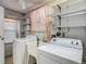 Laundry room with washer, dryer, sink, shelving, and natural light at 7736 Gaston Dr, Port Richey, FL 34668
