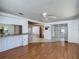Spacious living room with wood flooring and an open layout leading to the kitchen and sunroom at 7736 Gaston Dr, Port Richey, FL 34668