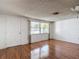 Bright living room with hardwood floors, textured walls, and a large window at 7736 Gaston Dr, Port Richey, FL 34668