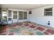 Covered and enclosed patio featuring decorative stone flooring and exterior access at 7736 Gaston Dr, Port Richey, FL 34668