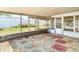 Screened patio with colorful tile design, pebbles, and a door to the back yard at 7736 Gaston Dr, Port Richey, FL 34668