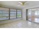 Bright sunroom with tile floors, ceiling fan, and sliding glass door leading to the interior at 7736 Gaston Dr, Port Richey, FL 34668