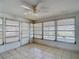 Comfortable sunroom with tile flooring, plenty of windows, and a ceiling fan at 7736 Gaston Dr, Port Richey, FL 34668