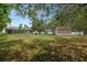 Expansive backyard featuring a shed, lush greenery, and a screened-in pool at 8382 Christopher Ln, Weeki Wachee, FL 34613