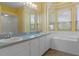 Bright bathroom with a double sink vanity and a large soaking tub near a bay window at 8382 Christopher Ln, Weeki Wachee, FL 34613