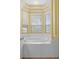 A bright bathroom featuring a tub with tiled platform in front of a bay window at 8382 Christopher Ln, Weeki Wachee, FL 34613