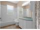 Bright bathroom with tub, shower, and white vanity with blue countertop at 8382 Christopher Ln, Weeki Wachee, FL 34613