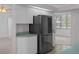 A modern stainless steel refrigerator complements the kitchen's clean, white cabinetry at 8382 Christopher Ln, Weeki Wachee, FL 34613