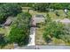 An aerial view of the home showcases its landscaped yard, long driveway, and inviting curb appeal at 8402 Lake Hill Ct, Spring Hill, FL 34608