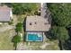 Aerial view of a home with a screened-in pool and well-manicured backyard, surrounded by lush greenery and mature trees at 8402 Lake Hill Ct, Spring Hill, FL 34608