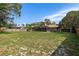 A large backyard showing the fenced-in area with a screened in porch on the rear of the house at 8402 Lake Hill Ct, Spring Hill, FL 34608