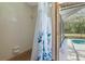 Bathroom with a tiled shower/tub, floral curtain and pool view through screen door at 8402 Lake Hill Ct, Spring Hill, FL 34608