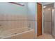 Tiled bathroom featuring a tub with jets and a separate glass-enclosed shower at 8402 Lake Hill Ct, Spring Hill, FL 34608