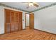 Bedroom featuring light hardwood floors, ceiling fan, closet and neutral paint at 8402 Lake Hill Ct, Spring Hill, FL 34608