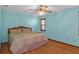 Comfortable bedroom featuring wood-look floors, a ceiling fan, and a serene atmosphere at 8402 Lake Hill Ct, Spring Hill, FL 34608