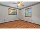 Bedroom showcasing light hardwood floors, ceiling fan, 2 windows and neutral paint at 8402 Lake Hill Ct, Spring Hill, FL 34608