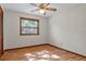 Bedroom featuring light hardwood floors, ceiling fan, and window with blinds at 8402 Lake Hill Ct, Spring Hill, FL 34608