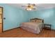 Comfortable bedroom featuring wood-look floors and a ceiling fan, providing a serene retreat at 8402 Lake Hill Ct, Spring Hill, FL 34608
