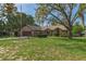 Inviting single-story home featuring a large, well-maintained front lawn and mature trees for shade at 8402 Lake Hill Ct, Spring Hill, FL 34608