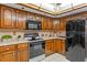 Cozy kitchen featuring wood cabinetry, light countertops, and black appliances at 8402 Lake Hill Ct, Spring Hill, FL 34608