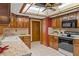 Kitchen showcasing wood cabinets, an oven range, and a sunlit ceiling fixture at 8402 Lake Hill Ct, Spring Hill, FL 34608