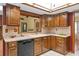 Traditional kitchen featuring wood cabinetry, tile backsplash, and modern black dishwasher at 8402 Lake Hill Ct, Spring Hill, FL 34608