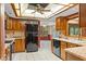 Kitchen with wood cabinets, tile backsplash, stainless steel sink, and black appliances at 8402 Lake Hill Ct, Spring Hill, FL 34608
